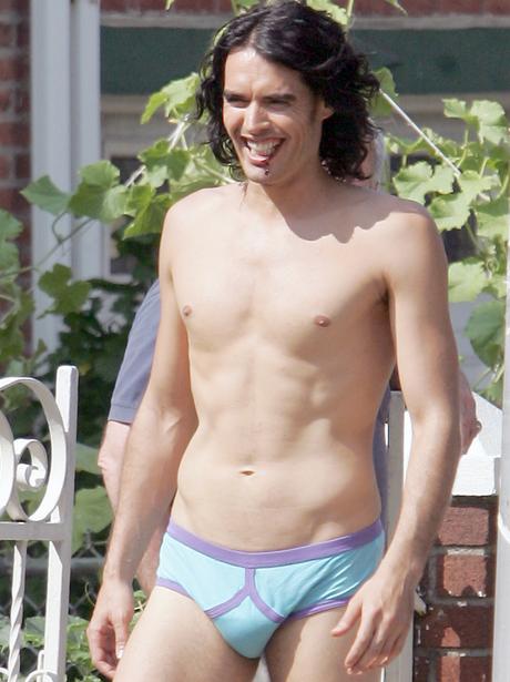 Russell Brand wearing nothing but black socks and colorful briefs on set of...