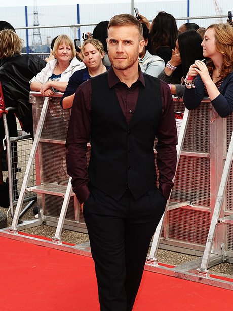 Gary Barlow wows on the red carpet in a black shirt and matching suit