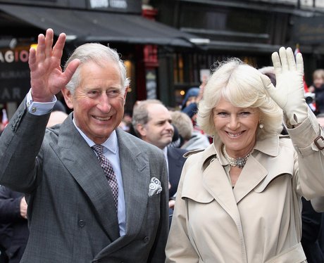The Prince of Wales and Duchess of Cornwall smile and wave