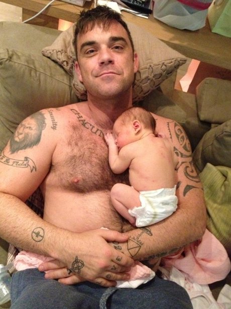 Robbie Williams holding his baby girl Teddy