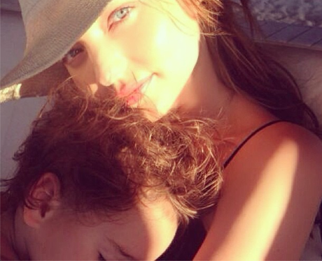 Mirander Kerr holds her son in her arms
