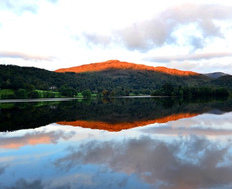 The sun rises over a lake in The Lake District