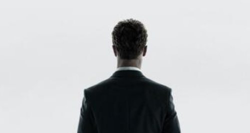 A man in a suit facing out of the window
