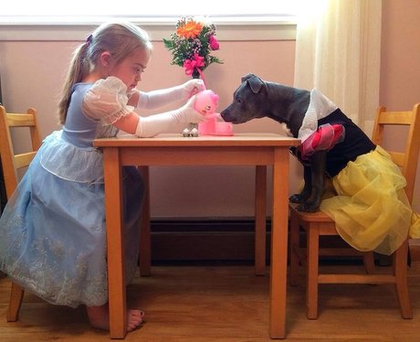 A girl having a tea party with a dog