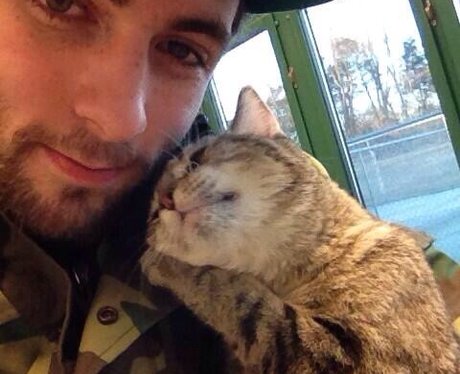 A man with a cat on his shoulder