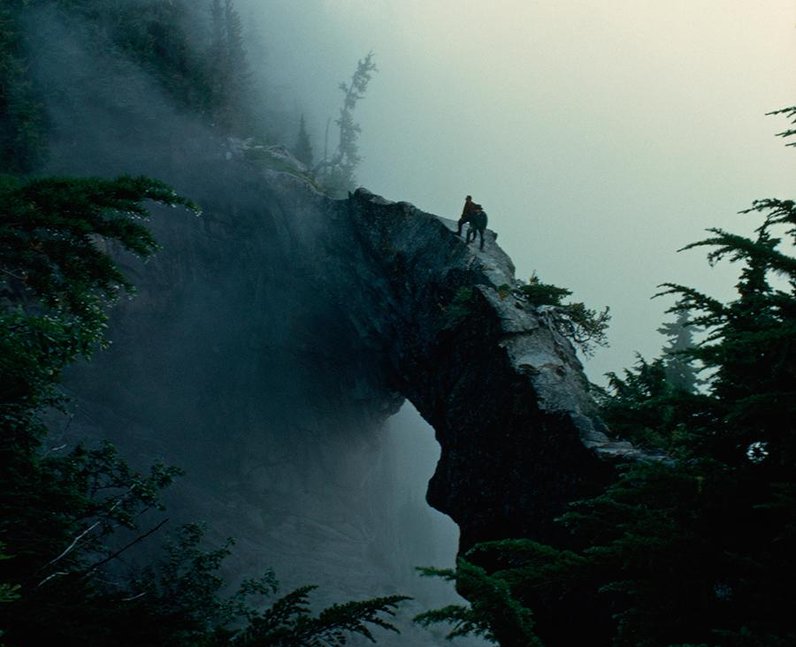 Two hikers cross a bridge