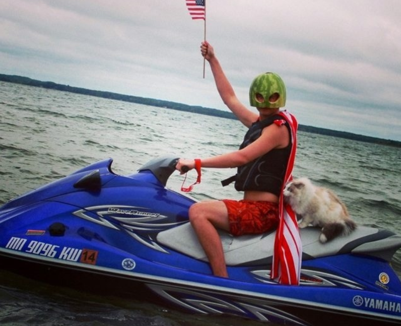 A man riding a jet ski with a cat on the back