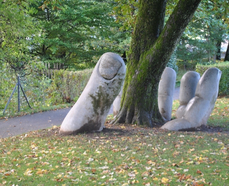 A hand sculpture around a tree