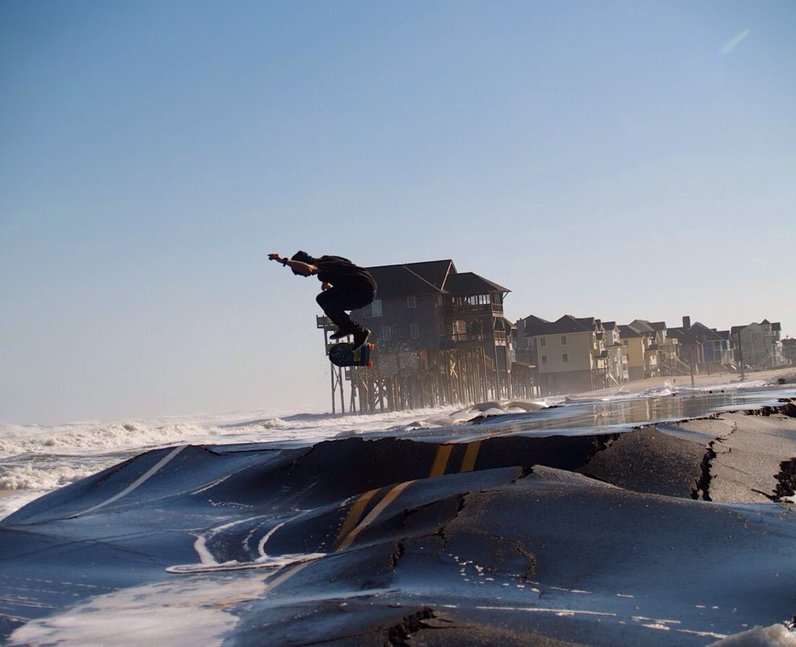 A skater doing tricks on the beach