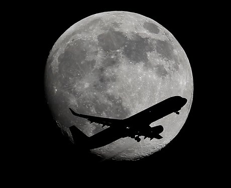 A plane in front of the Supermoon 