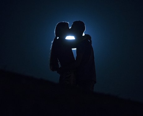 A couple kiss in front of The Harvest Moon