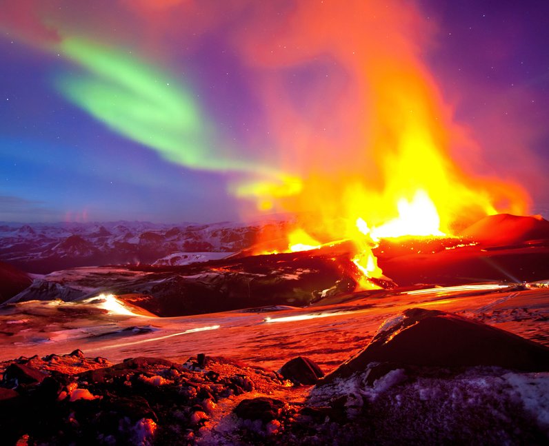 Flames from a living volcano mix with the aurora in the skies above ...