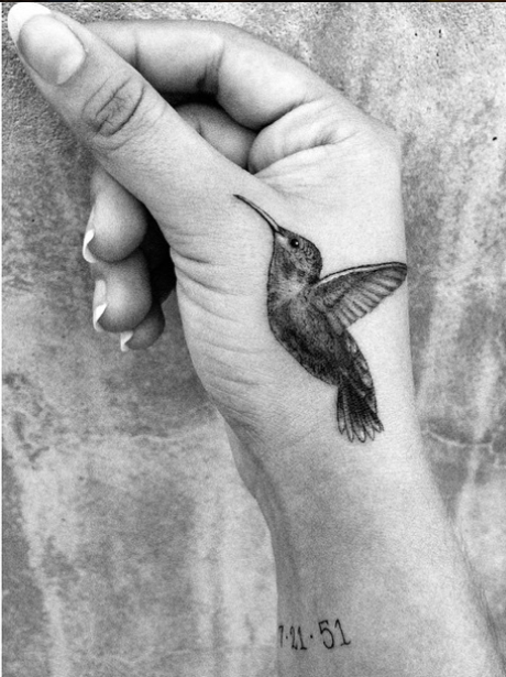 black and white hummingbird tattoo on a hand