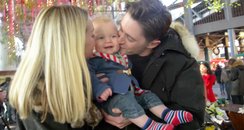 mum and dad kissing a baby