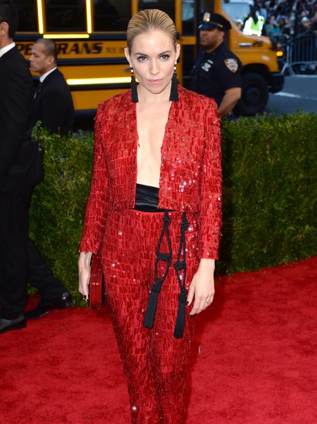 Sienna Miller parades a bare chest in a revealing red suit. - Met Gala