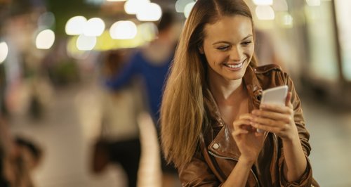 Woman using mobile phone and smiling