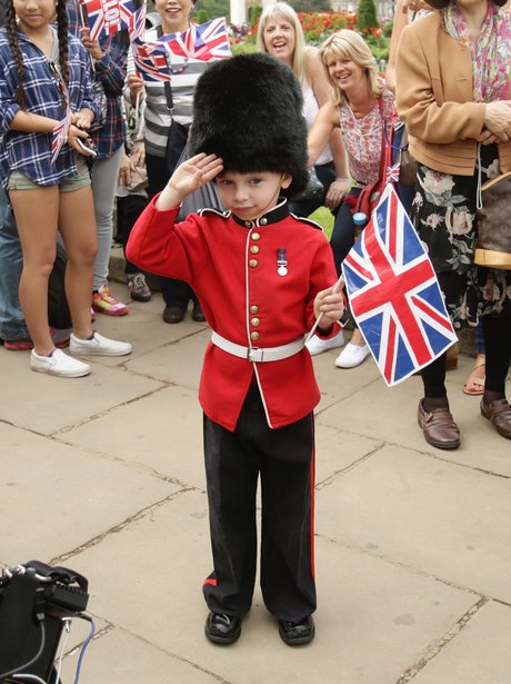 A young spectator waiting for the Queen dressed as a member of the ...