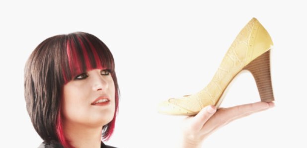 Woman holding up a high heeled shoe